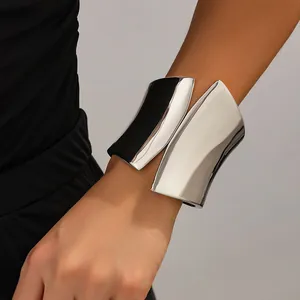 Close-up of wide asymmetrical silver metal cuff bracelet on model's arm
