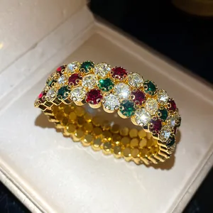 Dettaglio macro di bracciale retrò placcato oro con cristalli scintillanti rossi, verdi e bianchi