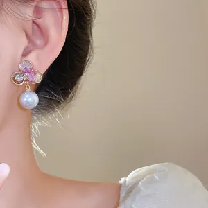 Close-up detail of elegant floral crystal drop earring featuring a lustrous white pearl