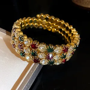 Primo piano di un bracciale dorato a tre file in stile vintage con cristalli colorati