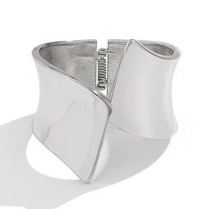 Macro view of an asymmetrical wide metal cuff bracelet with silver polished finish
