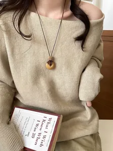 Detail of a vintage wooden semi-circle pendant necklace on a beige knit sweater