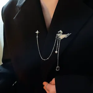 Nahaufnahme einer silbernen Pegasus-Brosche mit Stern- und Quastenketten auf Blazer