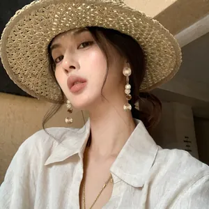 Detailed macro view of elegant gold metal textured round tassel earrings on Asian model