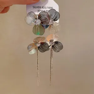 Detailed close-up of gold-plated silver needle flower tassel earrings with crystal center