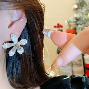 Primer plano de elegantes pendientes de flores plateadas, estilo coreano sofisticado.