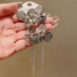 Detailed macro view of large flower tassel earrings with a sparkling center crystal