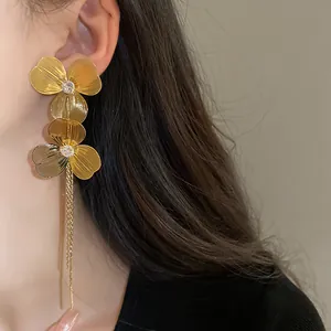 Detailed view of gold-plated flower tassel earrings with zircons on an Asian model.