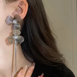 Elegant silver-plated flower tassel earrings with intricate petal design worn by model