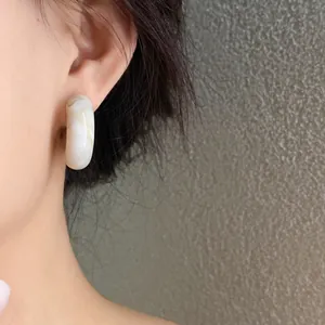 Close-up detail showing the texture of vintage marbled C-shaped acrylic stud earrings