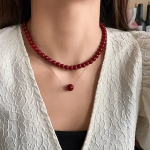 Detail shot of elegant double-layered Ankora red pearl necklace worn by a model