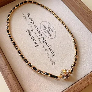 Collier élégant entrelacé de cuir avec pendentif boule magnétique en cristal.