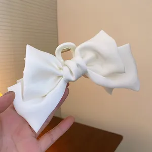 Detailansicht der großen weißen Haarklammer mit Stoffschleife und elegantem Faltenwurf.