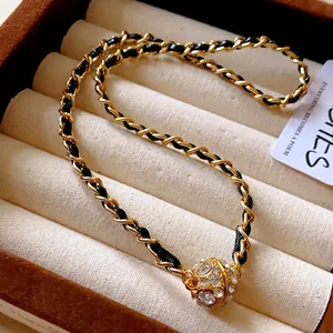 Collier chaîne dorée élégant avec cuir noir tressé et pendentif boule en cristal