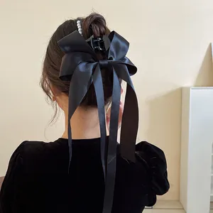 Detailansicht einer großen schwarzen Satin-Schleifen-Haarklammer mit eleganten Perlen