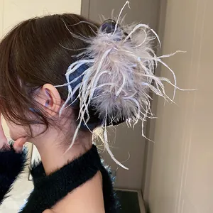 Detail einer eleganten grauen Feder-Haarklammer, gestylt an einem braunen Haarknoten