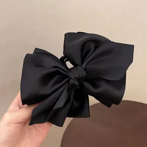 Detailansicht einer eleganten, übergroßen schwarzen Satinschleifen-Haarklammer für Damen