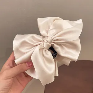 Detailaufnahme einer eleganten Haarklammer mit champagnerfarbener Satinschleife