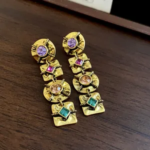 Detailed view of vintage gold-tone earrings with colorful square and round rhinestones
