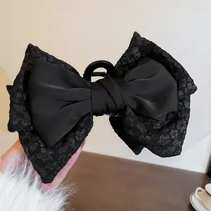 Eleganter großer schwarzer Schleifen-Haarclip mit floralem Muster und Satin-Finish.