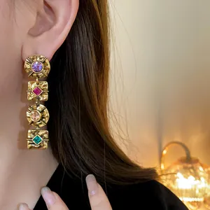 Vintage gold-toned drop earrings with multi-colored rhinestones and hammered texture.