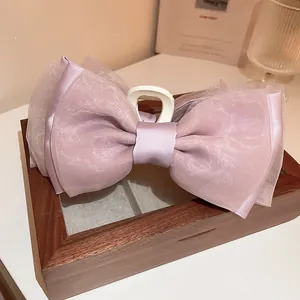 Detailansicht einer rosa Organza-Schleifen-Haarklammer mit eleganter Satinstruktur
