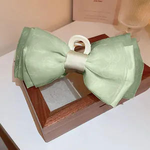 Detailansicht einer eleganten salbeigrünen Haarklammer mit einer Organza-Schleife