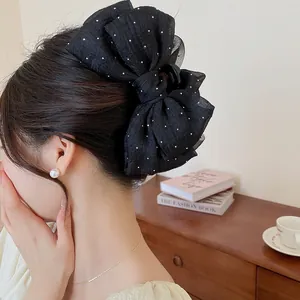 Detailansicht einer eleganten großen schwarzen Haarklammer mit gepunkteter Schleife.