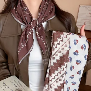 Detail shot of vintage printed silk-like headscarf styled on a leather jacket