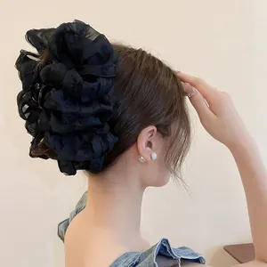Detaillierte Nahaufnahme einer großen schwarzen Haarklammer mit eleganter Netzschleife im Haar