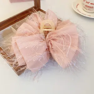 Detailansicht der eleganten rosa Schleifen-Haarklammer mit weichen Federfransen-Details