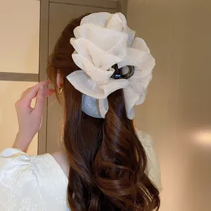 Eleganter cremefarbener Haarclip aus gerafftem Stoff in langem, welligem Haar