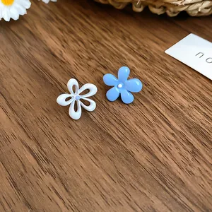 Dettaglio ravvicinato di orecchini a lobo a fiore in smalto blu e bianco per lei.
