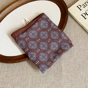 Detailed view of vintage geometric pattern square scarf on wooden tray.