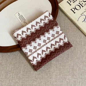 Macro detail of the vintage brown and white geometric pattern on a soft cotton headscarf