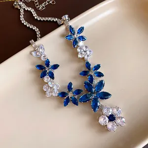 Dettaglio della collana con fiori di zircone blu e bianchi stile lusso moderno