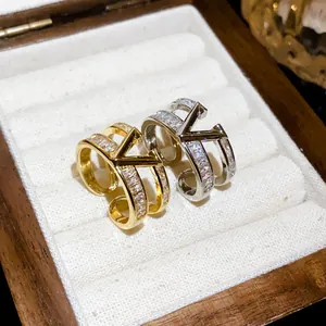 Macro view of gold and silver V-shaped open rings with zirconias in a wooden jewelry box