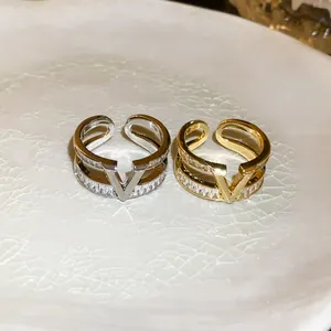 Close-up of gold and silver plated V-shaped rings with sparkling zircon inlay