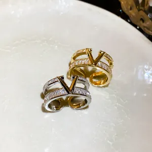 Macro detail of a double-layered gold and silver V-shaped open ring with pavé zircons