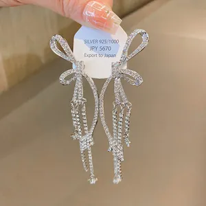 Detail von Schleifenohrringen mit Silbernadler und funkelnden langen Strass-Quasten