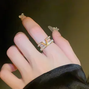 Detail view of gold-plated V-shaped open ring with sparkling zircon inlay on hand