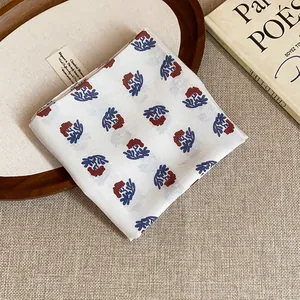 Detailed view of retro floral print cotton bandana folded neatly on a textured linen background