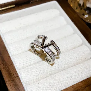 Detailed close-up of a silver double-layer open ring encrusted with clear cubic zirconia