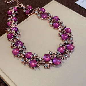 Primer plano de collar vintage de estilo corte con cuentas púrpuras y hojas de oro rosa