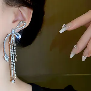 Elegante Nahaufnahme von funkelnden Strass-Schleifen-Ohrringen mit Sternanhängern
