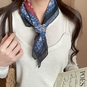 Close-up detail of a vintage printed fabric neck scarf styled with a classic front knot