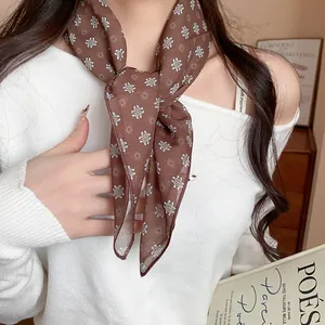 Close-up detail of a brown floral print silk scarf styled as a retro literary necktie