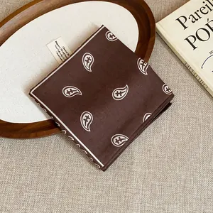 Detailed top-down view of a retro brown paisley print bandana on a wooden tray decor