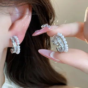 Close-up detail of elegant 18k gold plated pearl and zircon clip-on earrings for women