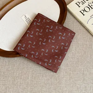 Close-up detail of a vintage brown floral square scarf with blue paisley patterns